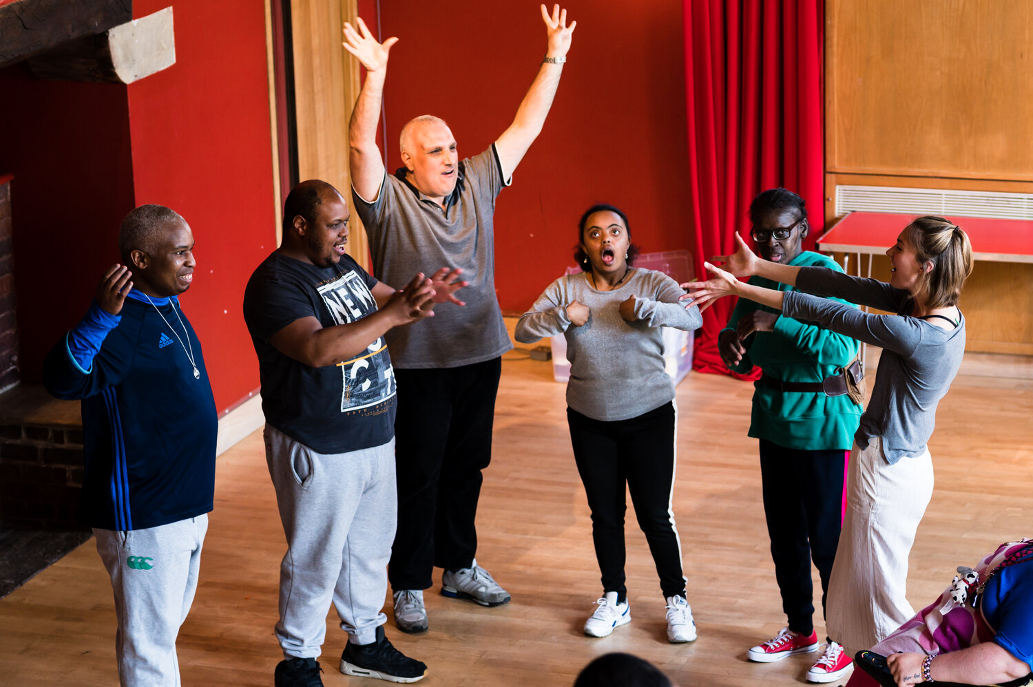 People in a workshop, one man raises his hands in happiness