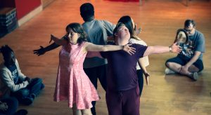 People stand back to back with arms outstretched
